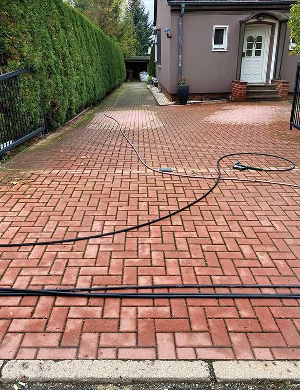 Hof mit rotem Pflaster und schwarzen Kabeln