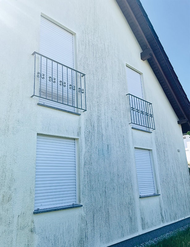 Hauswand mit geschlossenen Rollläden und Balkonen