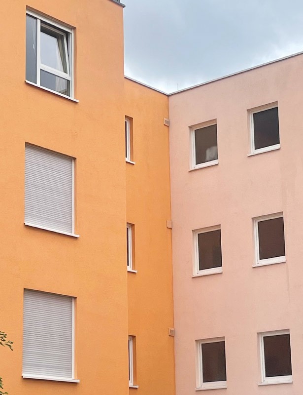 Zweifarbiges Gebäude mit vielen Fenstern.